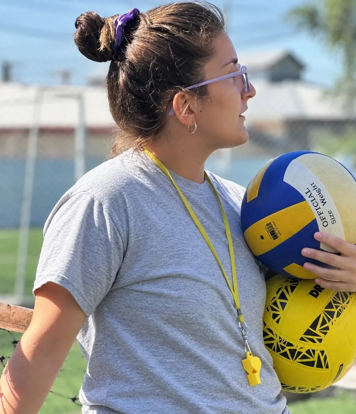 Valentina dando clase en una cancha al aire libre, con pelotas bajo el brazo